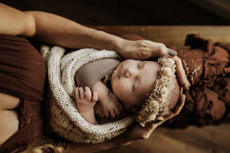 Family Photography, newborn swaddled wearing a flower crown on moms lap